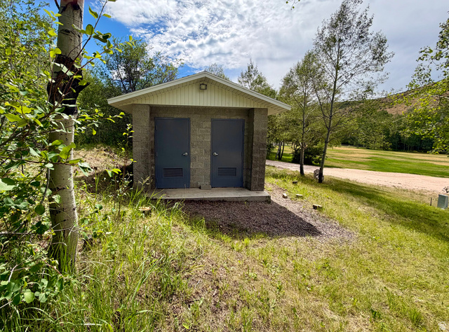 1133 Paris Canyon Road Paris, ID 83261 - Photo 46 of 75 Outside well-built bathroom structure featuring a pitched roof, light-toned siding, and a security light