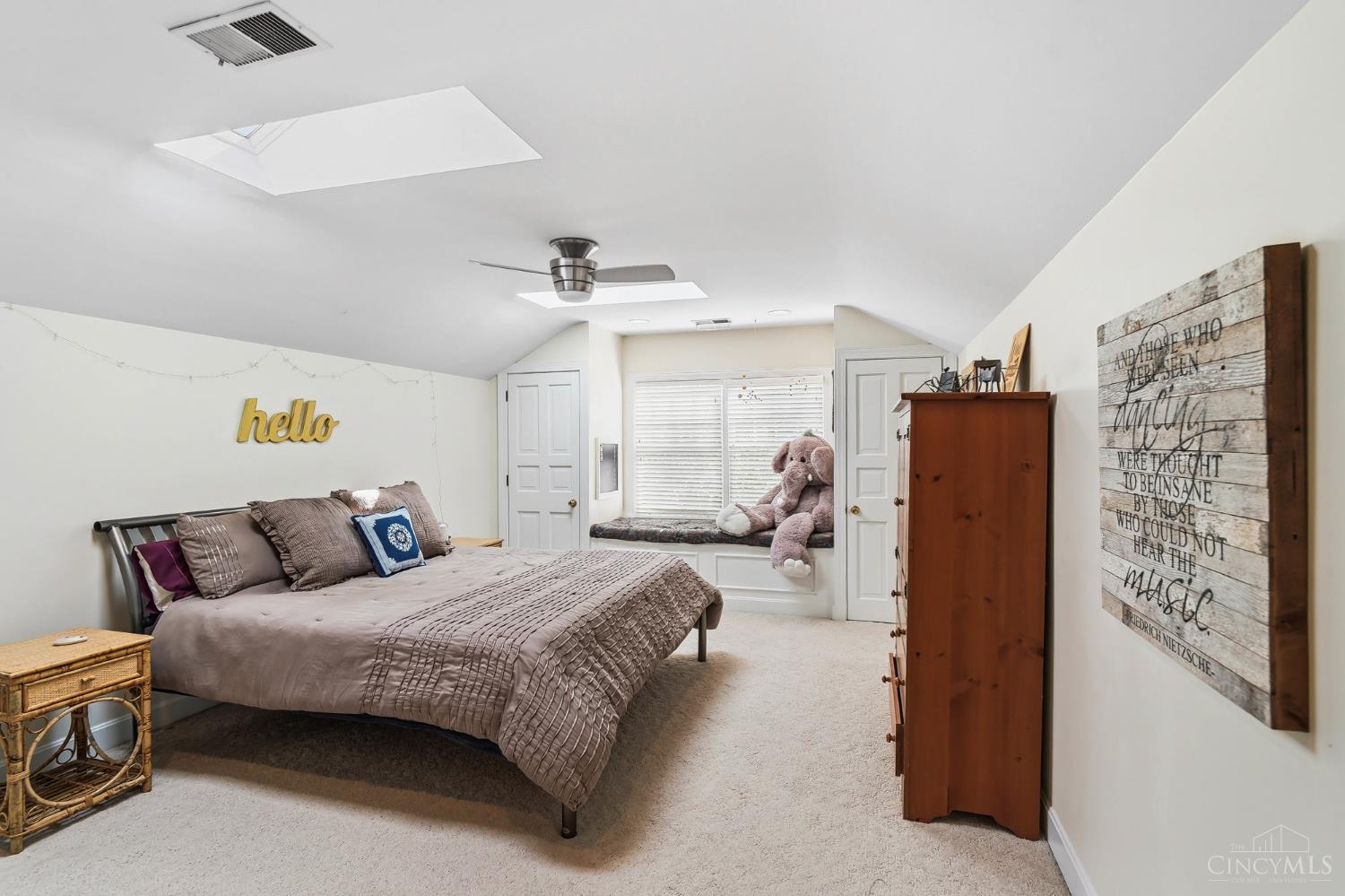 2780 Walsh Road Cincinnati, OH 45208 - Photo 35 of 68 This spacious upper-level bedroom offers a comfortable retreat with an airy, light-filled feel and charming architectural character. Vaulted ceilings are accented by skylights that bring in abundant natural light, while a window seat provides a cozy nook overlooking the outdoors. Generous proportions allow for flexible use, easily accommodating both sleeping and lounge or study areas. Just off the main space, a tucked-away reading nook beneath the sloped ceiling creates a quiet, private retreat—perfect for a desk, study area, or curling up with a book—adding both versatility and a sense of thoughtful separation to the room.