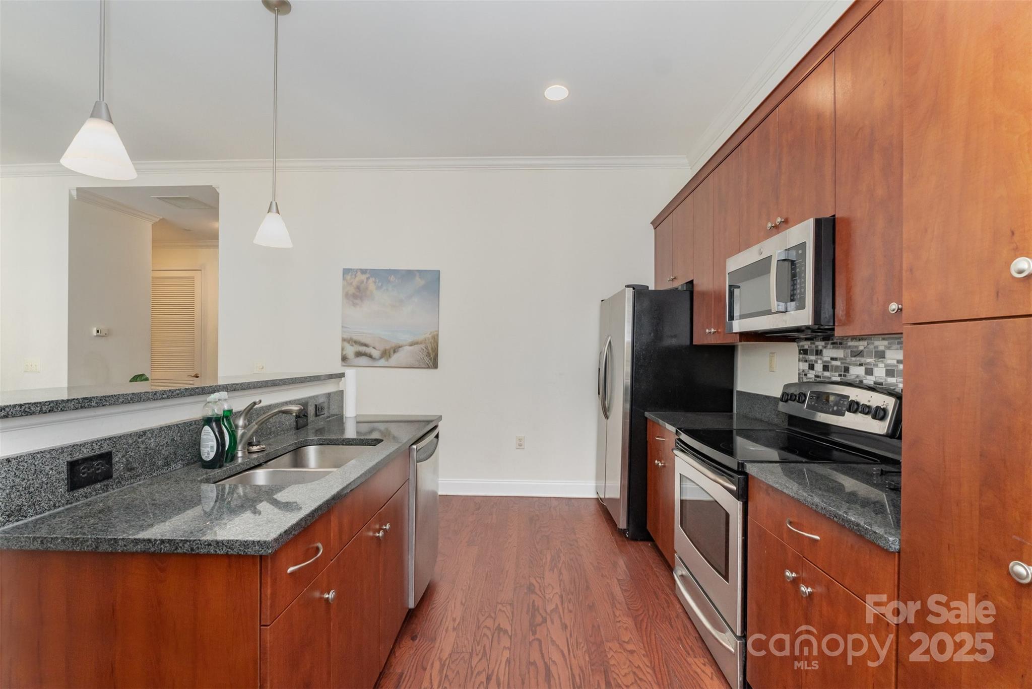 230 South Tryon Street, Unit 1105 Charlotte, NC 28281 - Photo 10 of 33 a kitchen with stainless steel appliances granite countertop a sink stove and refrigerator