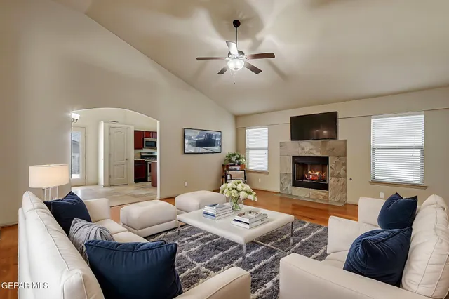an empty room with wooden floor fireplace and windows