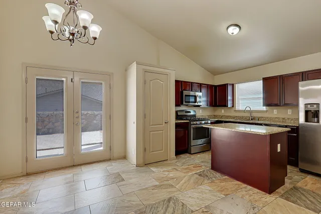 a kitchen with stainless steel appliances granite countertop a refrigerator stove and a sink