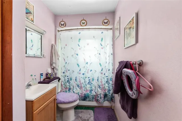 a bathroom with a shower curtain sink and toilet