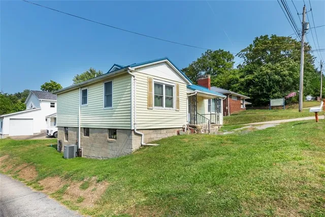 a front view of a house with a yard and trees