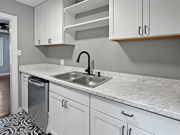 a kitchen with a sink a refrigerator a window and cabinets