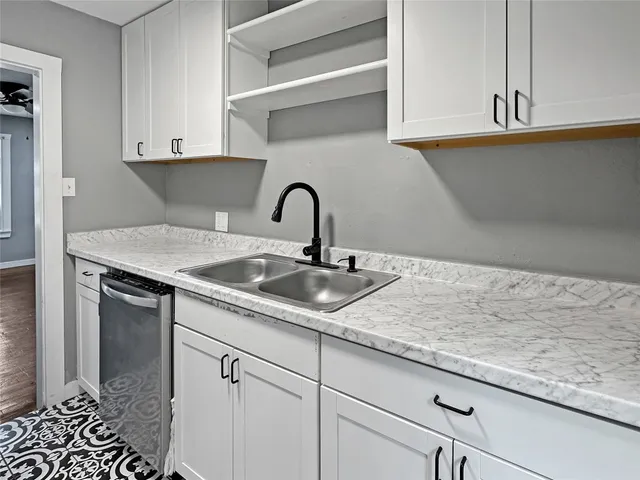 a kitchen with a sink a refrigerator a window and cabinets