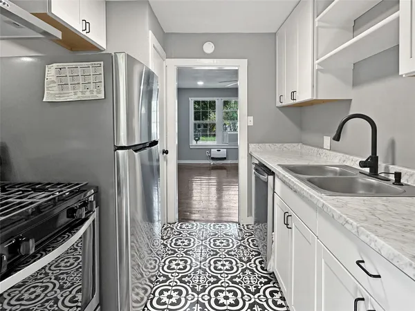 a metallic refrigerator freezer sitting inside of a kitchen