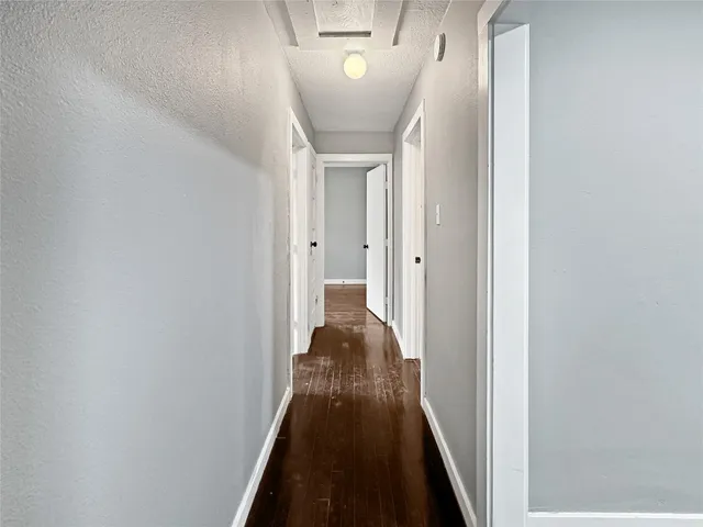 a view of a hallway with a livingroom and a bathroom with sink