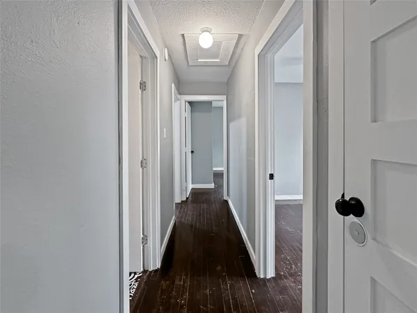 a view of an empty room with wooden floor