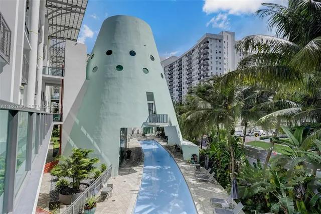 a palm tree sitting in front of a house with a yard