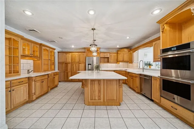 a kitchen with stainless steel appliances granite countertop a stove a sink dishwasher and a refrigerator