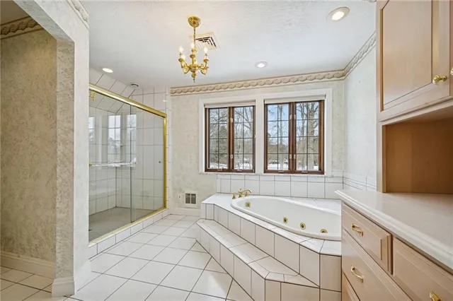 a spacious bathroom with a tub sink and mirror