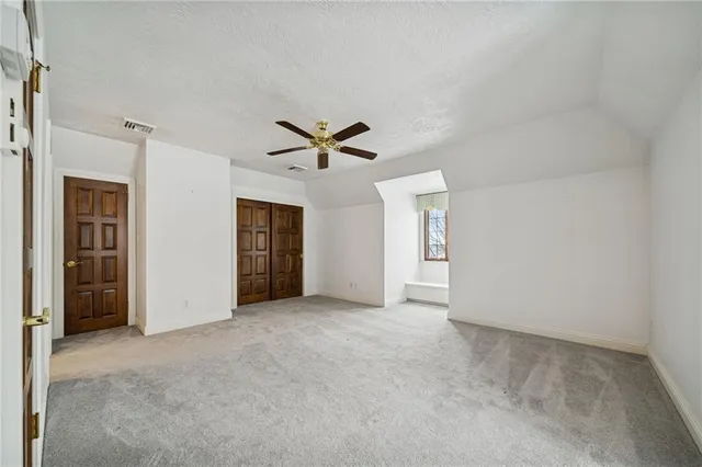 an empty room with closet and windows