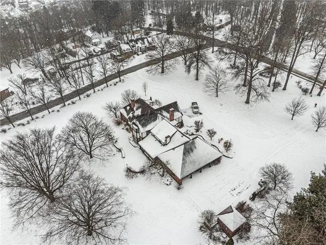 a front view of a house with a yard covered in snow