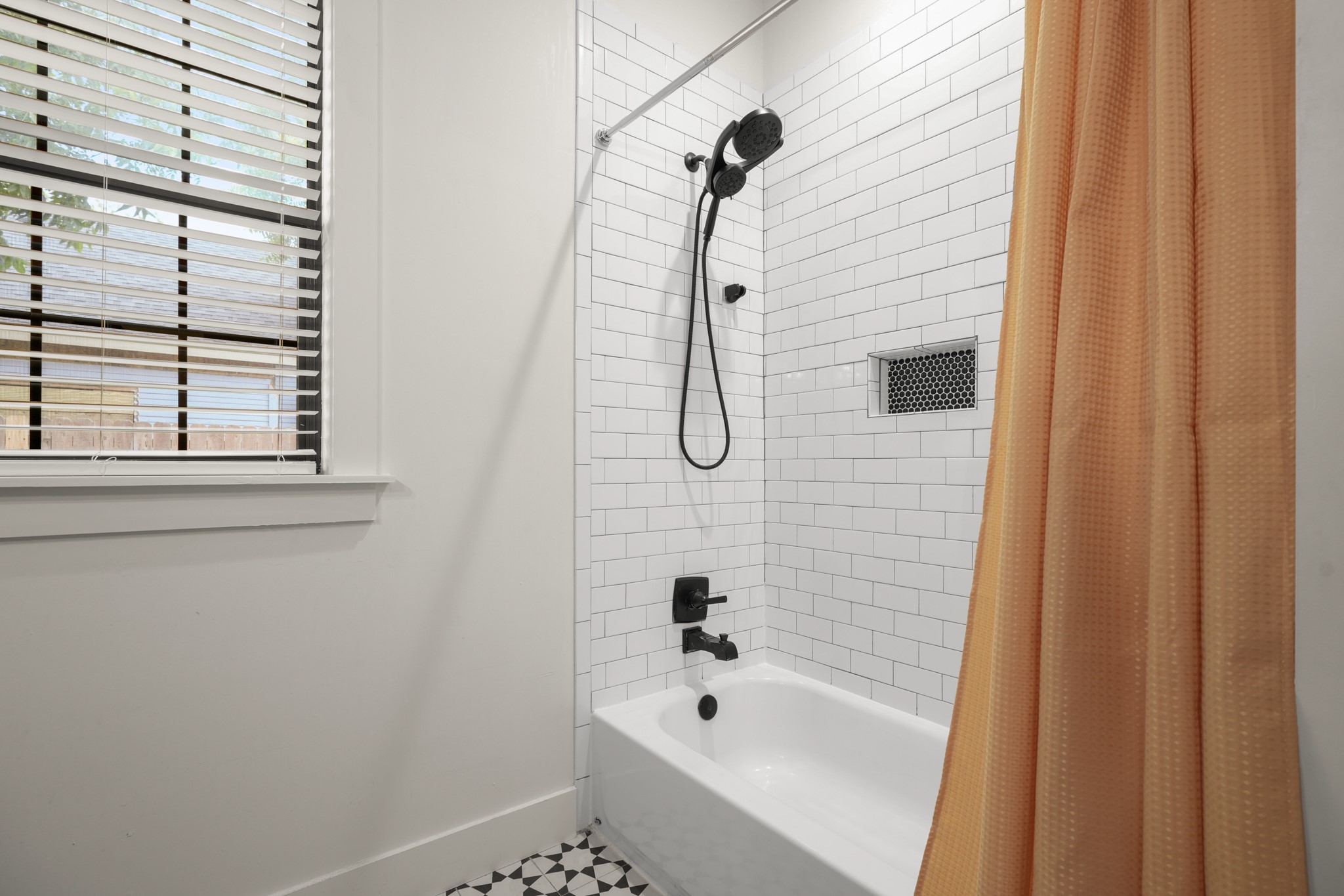 301 Old Thorndale Road Taylor, TX 76574 - Photo 29 of 29 A well-lit bathroom features a classic subway-tiled shower over a pristine tub, offering a relaxing retreat.