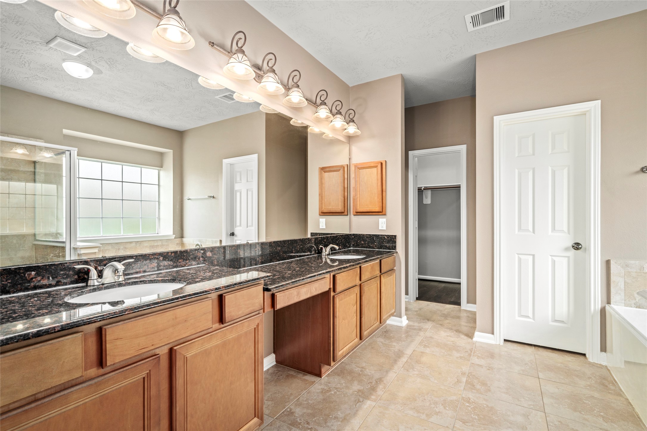 5307 Amber Sky Lane Rosharon, TX 77583 - Photo 25 of 50 Indulge in a double-sink vanity with granite countertops, abundant cabinetry, and designer lighting, a luxurious retreat designed for daily indulgence.