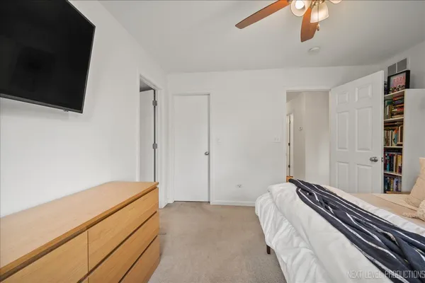a bedroom with a bed and a flat tv screen on the dresser