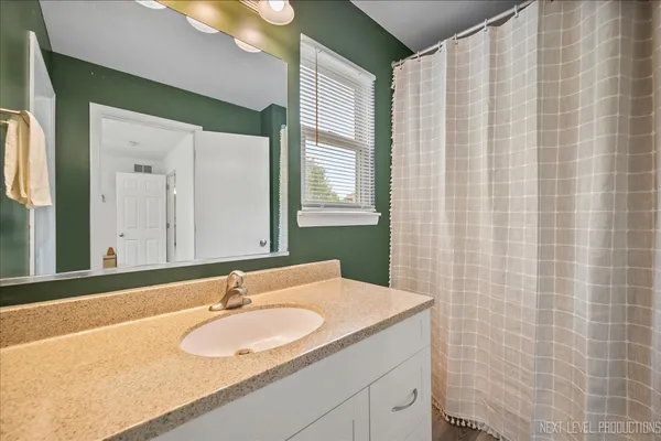 a bathroom with a granite countertop sink and a mirror