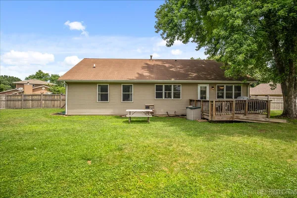 a backyard of a house with table and chairs