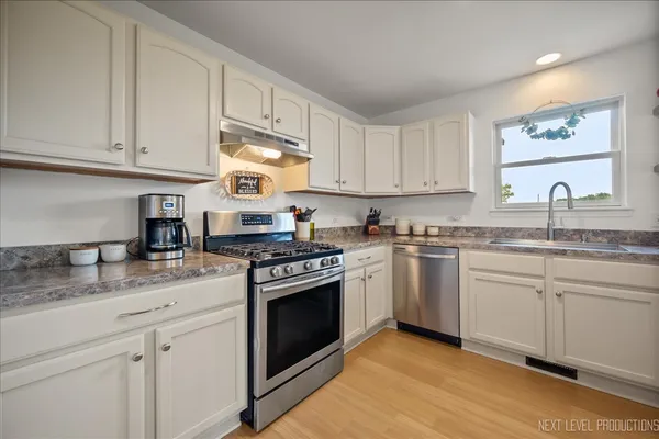a kitchen with granite countertop cabinets stainless steel appliances and a sink