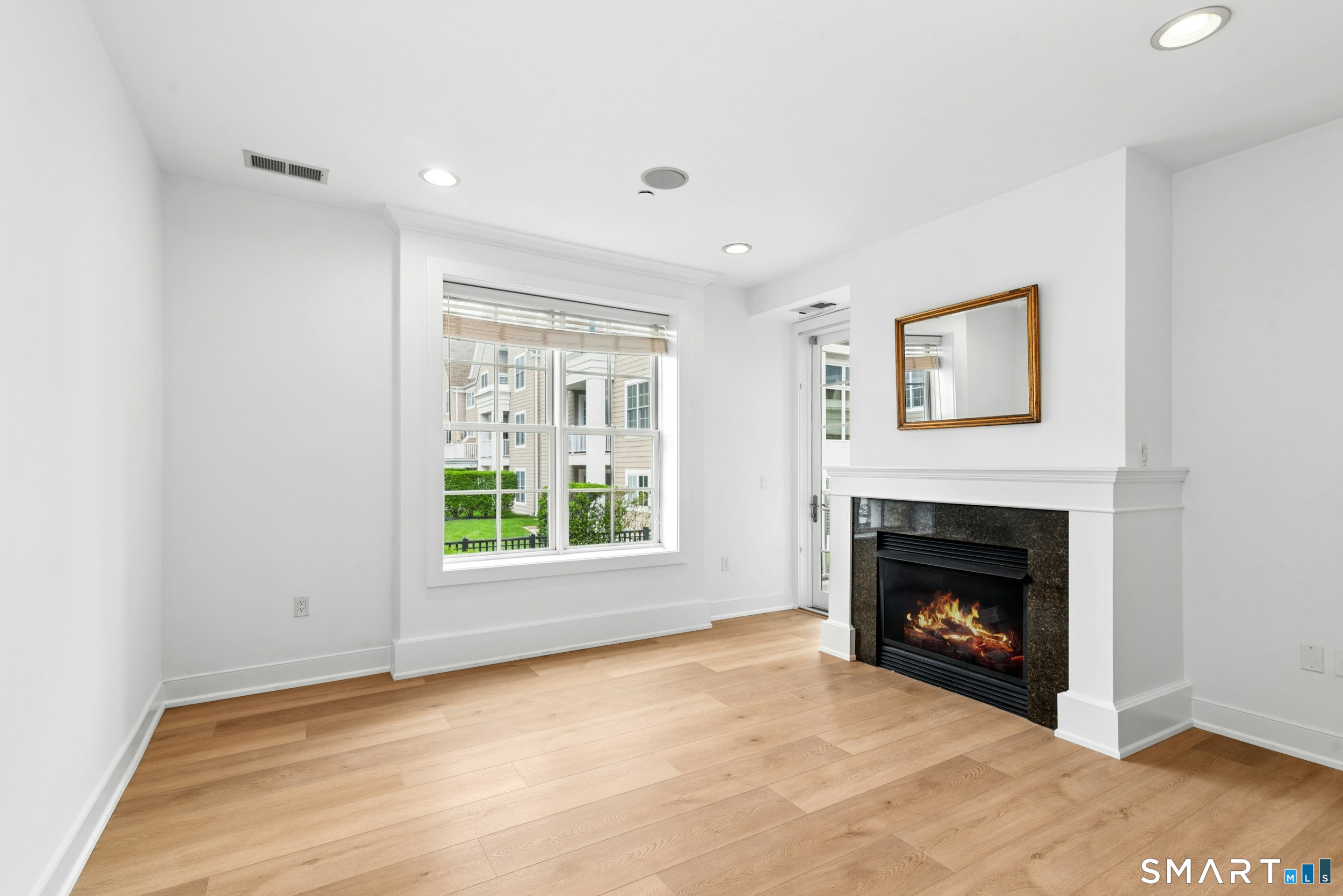 77 Havemeyer Lane, Unit 310 Stamford, CT 06902 - Photo 5 of 22 a view of an empty room with a fireplace and a window