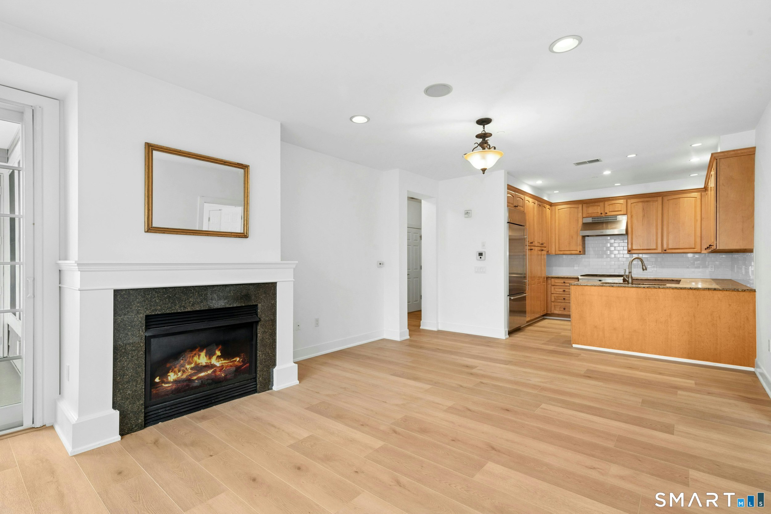 77 Havemeyer Lane, Unit 310 Stamford, CT 06902 - Photo 8 of 22 a large kitchen with a fireplace and a chandelier