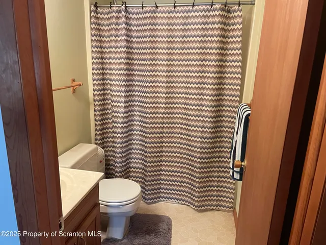 a bathroom with a toilet and a shower curtain