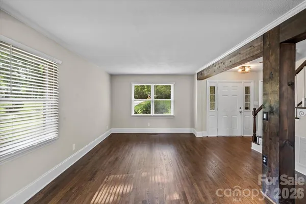 an empty room with wooden floor and a window