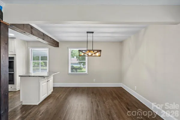 a view of a room with wooden floor a ceiling fan and windows