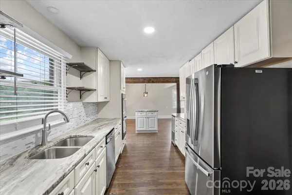 a kitchen with granite countertop a refrigerator and a sink