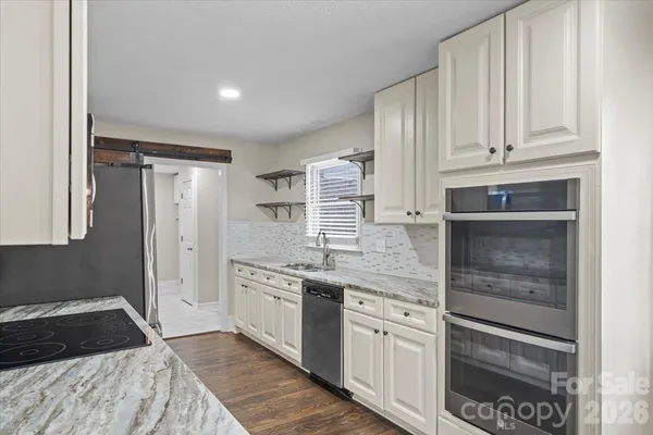 a kitchen with granite countertop cabinets stainless steel appliances and a sink