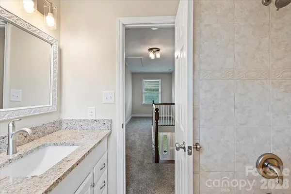 a bathroom with a granite countertop sink and mirror