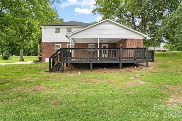 a view of a house with a backyard and deck