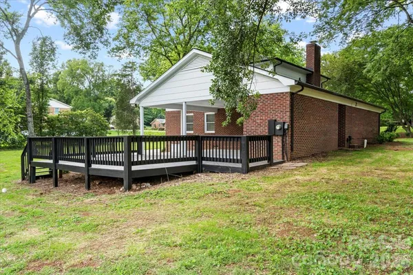 a view of a house with wooden fence and a bench