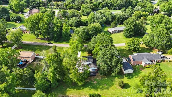 an aerial view of residential house with outdoor space and trees all around