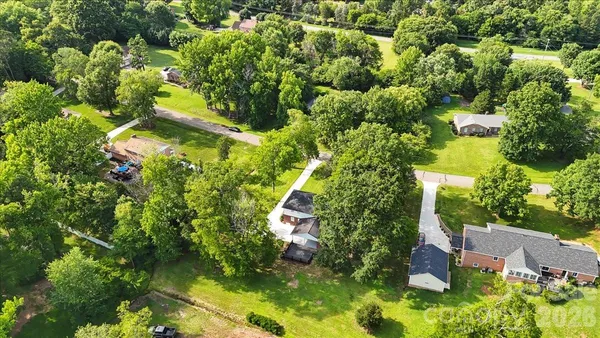 an aerial view of residential house with outdoor space and trees all around