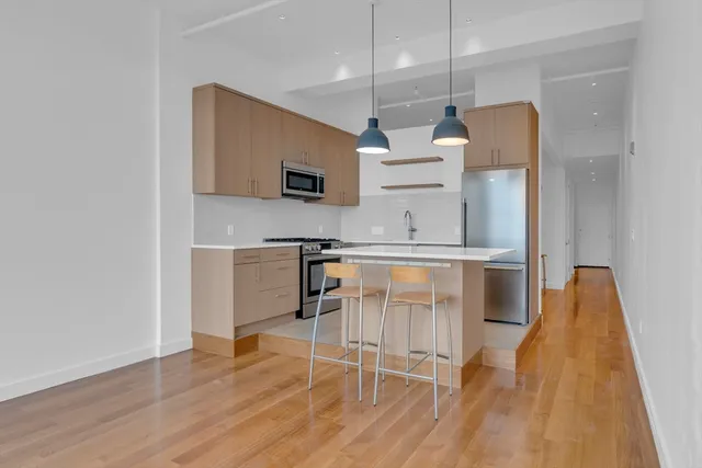 a kitchen with stainless steel appliances kitchen island granite countertop a stove a sink and a refrigerator