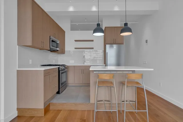 a kitchen with stainless steel appliances granite countertop a sink a stove and a refrigerator