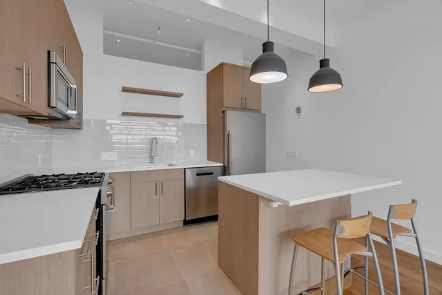 a kitchen with a table chairs and white cabinets