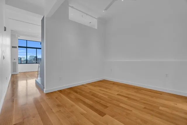 a view of empty room with wooden floor