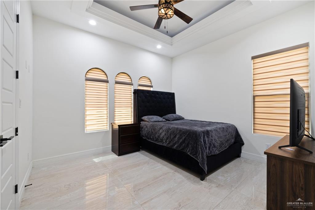 22303 Uresti Road Edinburg, TX 78542 - Photo 13 of 22 Bedroom featuring recessed lighting, ornamental molding, a tray ceiling, a ceiling fan, and light marble finish flooring