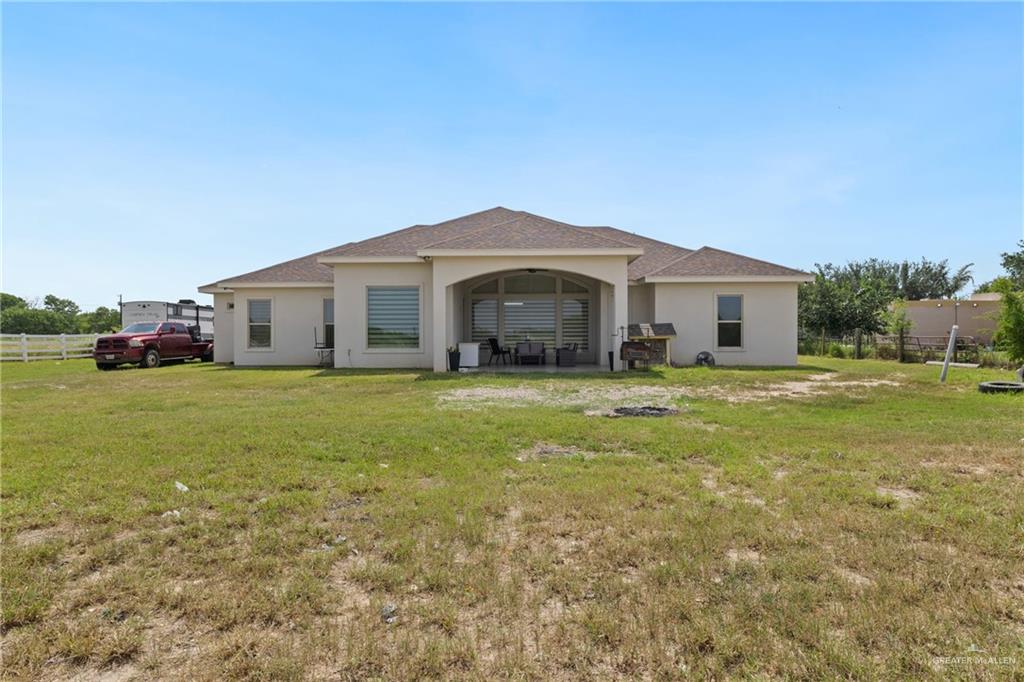 22303 Uresti Road Edinburg, TX 78542 - Photo 20 of 22 Back of house featuring stucco siding, roof with shingles, and a patio