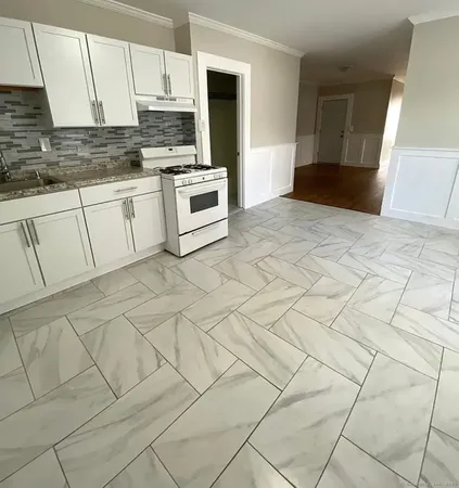 a kitchen with granite countertop white cabinets and stainless steel appliances