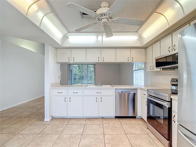 a kitchen with stainless steel appliances a stove refrigerator and cabinets