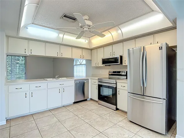 a kitchen with granite countertop a refrigerator oven a sink dishwasher and a refrigerator