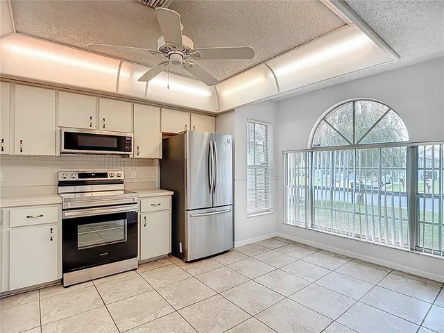 a open kitchen with white cabinets and stainless steel appliances
