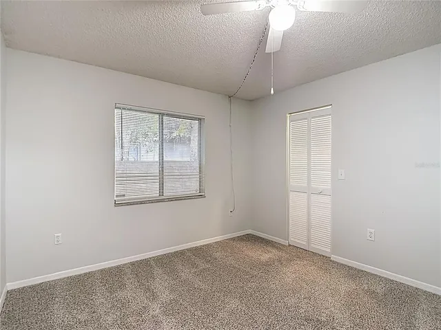 an empty room with windows and closet