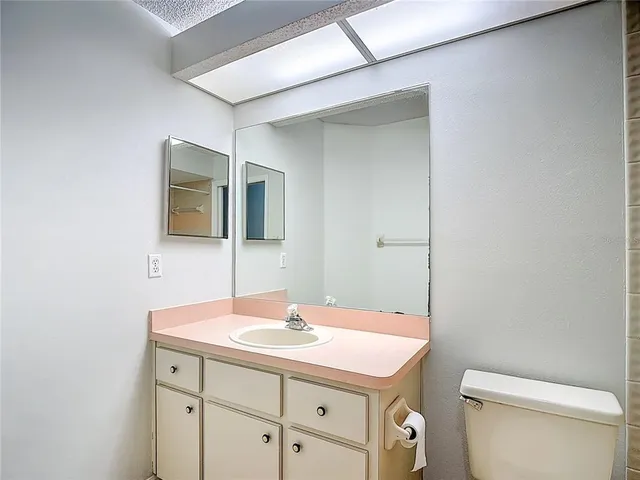 a bathroom with a sink a toilet and mirror