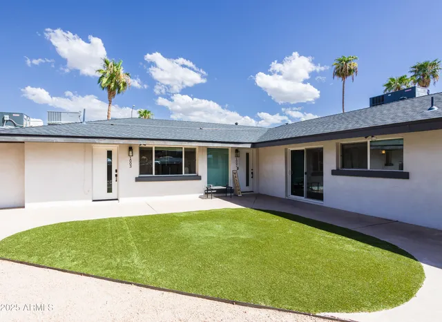 a view of a house with a swimming pool and a yard