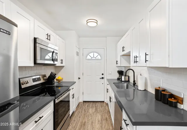 a kitchen with stainless steel appliances granite countertop a sink stove and refrigerator