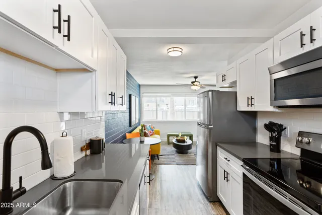 a kitchen with a sink a stove and cabinets
